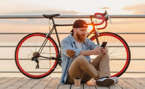 Man Playing Phone Near Bike